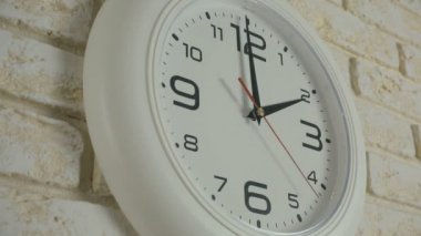 Timelapse saat on iki saat içinde. Tuğla duvara asılı yuvarlak beyaz saat.