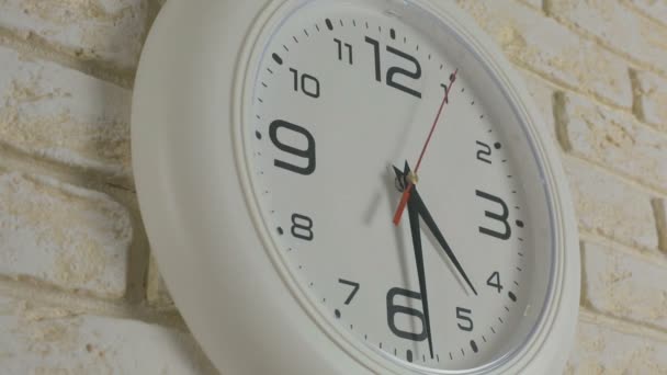 Temps quatre heures trente minutes. Timelapse. Horloge ronde blanche suspendue au mur de briques .