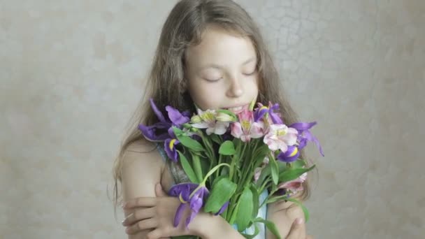 Beautiful happy girl enjoys bouquet flowers of irises and alstroemeria. — Stock Video