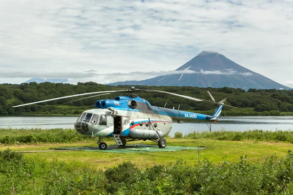Helicóptero no fundo Lago Kurile e vulcão Ilyinsky . — Fotografia de Stock