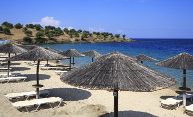 Şemsiye saman üzerinde plaj Porto Carras Grand Resort. 