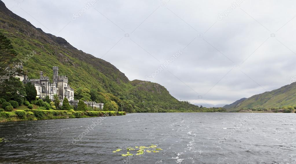 Kylemore Abbey in mountains on the lake.
