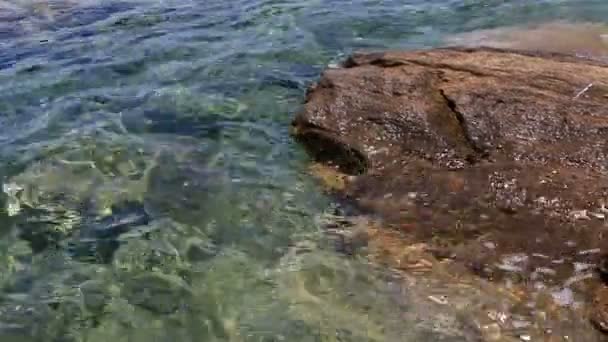 Klares Wasser der Ägäis spült die Felsen an Land. — Stockvideo