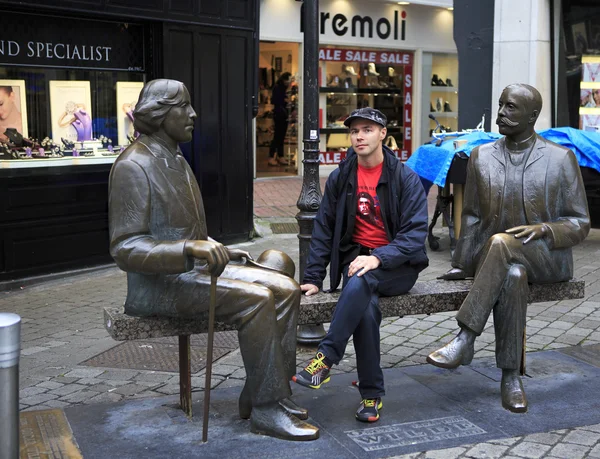 Tourist on the bench with Irish writer Oscar Wilde. — Stock Photo, Image