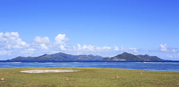 Helipad en la isla de La Digue en el fondo de la isla Praslin . — Foto de Stock