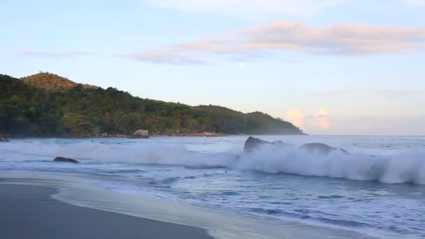 Wellen bei Sonnenaufgang am Strand anse lazio. — Stockvideo