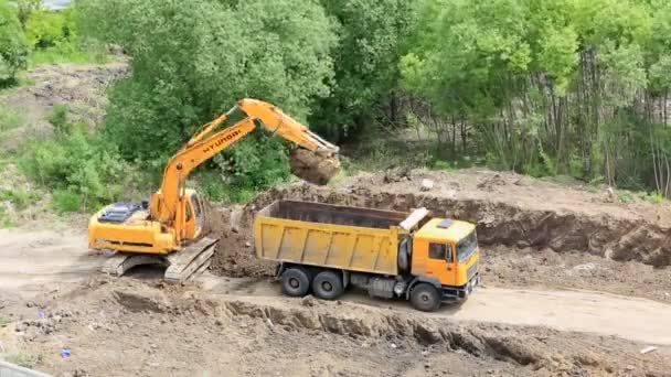 Excavatrice creuser une tranchée et des camions de charges au sol. Délai imparti — Video