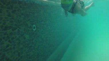 Havuzda yüzen küçük kız.