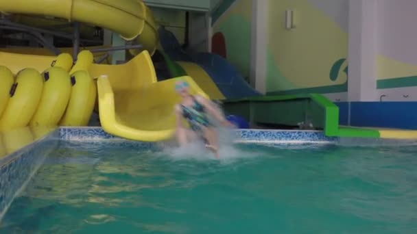 Meisje rijdt weg Wasser Rutsche in het zwembad. — Stockvideo