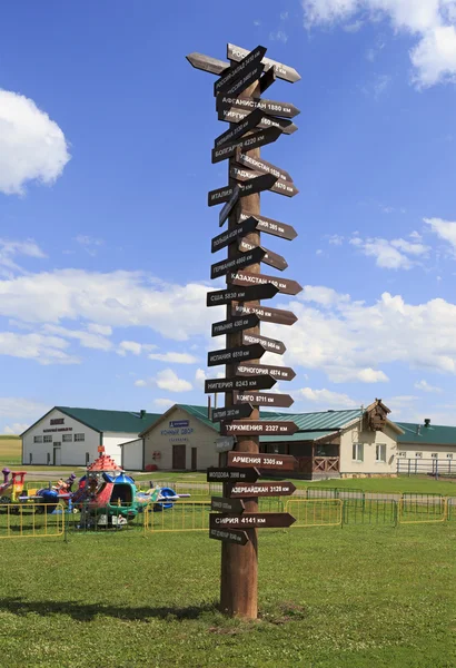 Informative column indicating direction of finding the different countries. Tourist Complex Siberian Podvorye. — Stock Photo, Image