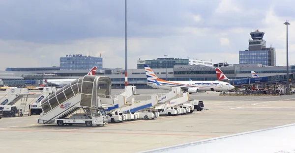 Commercial aircraft being serviced on the tarmac of an international airport.