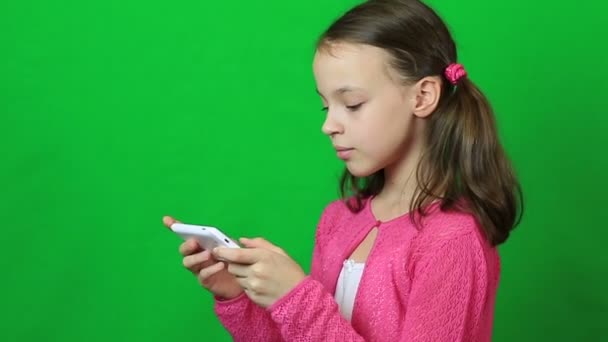 Весела маленька дівчинка зі смартфоном в руці . — стокове відео