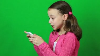 Belgili tanımlık smartphone üzerinde oynarken duygusal küçük kız.