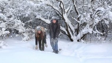 Mutlu güzel erkek ve kız kar kış Park yağmuruna eğleniyor.