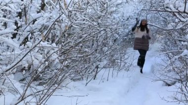 Güzel mutlu kız kış parkta yürüyüş ve karla kaplı ağaç dalları hayranım.