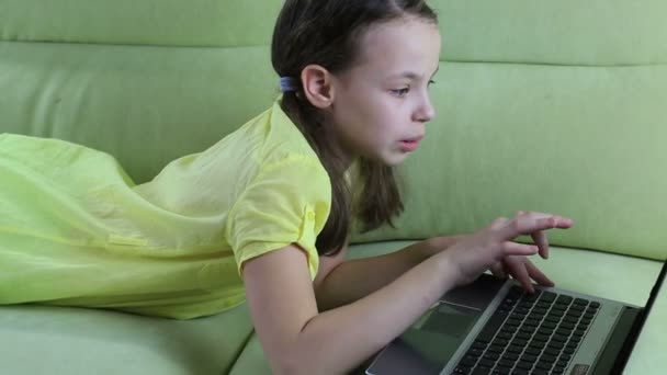 Hermosa niña hablando y escribiendo en el ordenador portátil . — Vídeo de stock