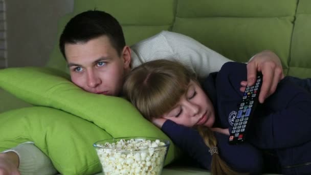 Junges Paar vor dem Fernseher mit Popcorn und schläft ein. — Stockvideo