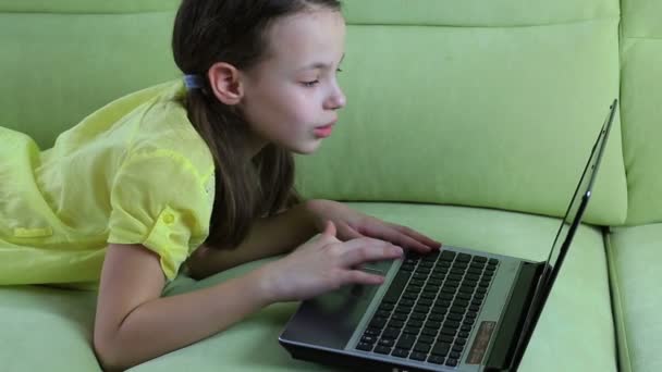 Hermosa niña hablando y escribiendo en el ordenador portátil . — Vídeo de stock