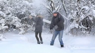 Mutlu güzel erkek ve kız kar kış Park yağmuruna eğleniyor.