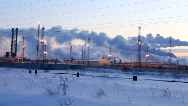 Refinería al atardecer fondo cielo. Tarde nevada helada de invierno. Panorama horizontal — Vídeo de stock