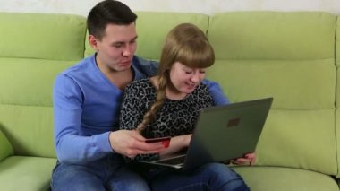 Komik duygusal çift alışveriş online ve plastik kredi kartı ile ödeme.