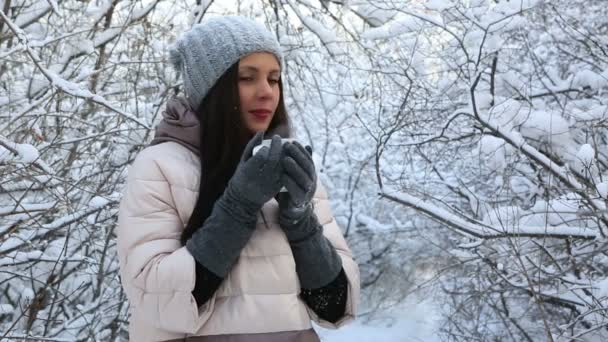 Belle fille heureuse se réchauffe avec du thé chaud. Arbres couverts de neige dans le parc d'hiver .