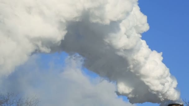 Зимний пейзаж дыма из дымовых труб растения против синего неба морозный туманный день — стоковое видео
