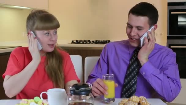 Negocios joven marido y mujer hablando en el teléfono inteligente en el desayuno. Están enamorados y cuidándose mutuamente. . — Vídeos de Stock