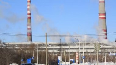 Termik santral güneşli soğuk günde. Endüstriyel duman boruları mavi gökyüzü karşı.