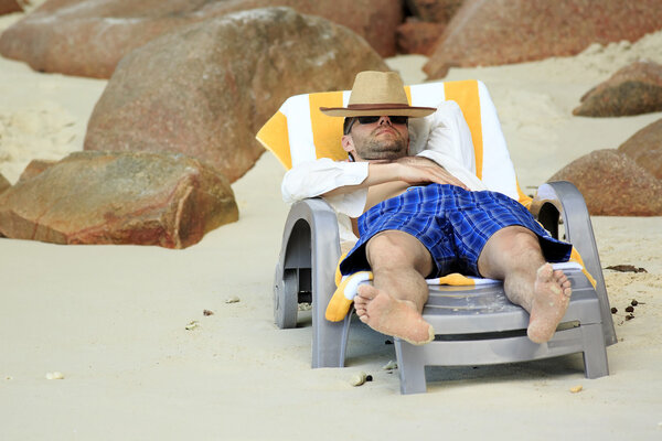 Tourist resting on a lounger. Sandy beach at the shores of India