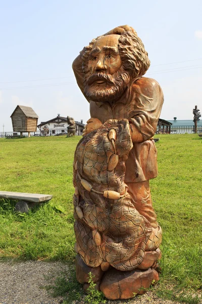 Old man with a seine. Wooden sculptures based on Pushkins fairy tales. — Stock Photo, Image