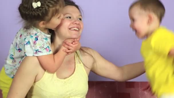 Χαρούμενη παιδάκια αγκάλιασμα και το φίλημα ευτυχισμένη μητέρα. — Αρχείο Βίντεο