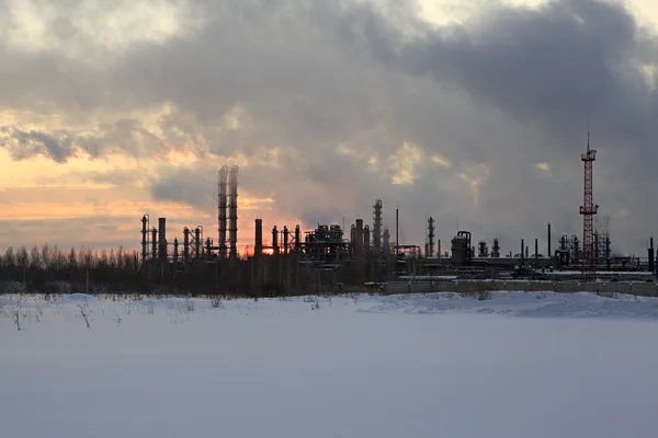 Refinería al atardecer fondo cielo. Tarde de invierno nevada helada . —  Fotos de Stock