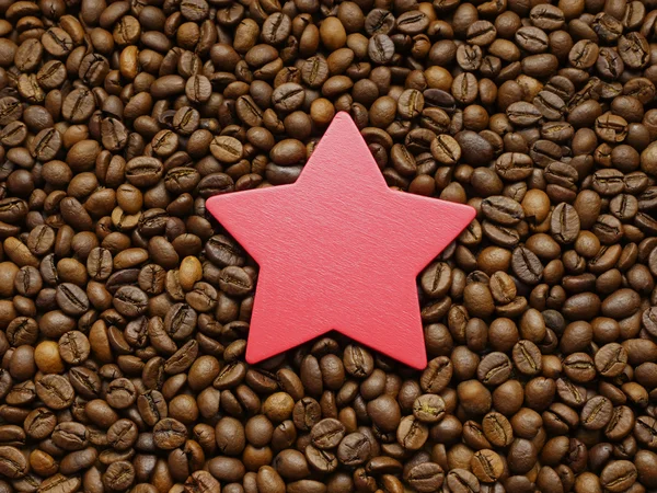 Sternchen auf Kaffeebohnen-Hintergrund. — Stockfoto