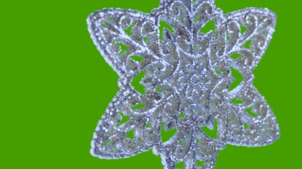 Ornament in the form of a snowflake on a green background. — Stock Video