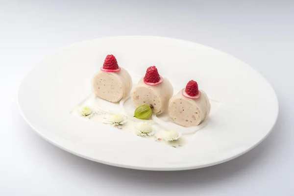 Banana rolls with raspberries on a white plate on a white backgr — Stok fotoğraf