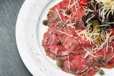 Carpaccio zeytin ve plaka üzerinde Parmesan ile