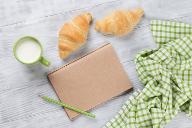 Taze kruvasanlar, süt ve not defteri