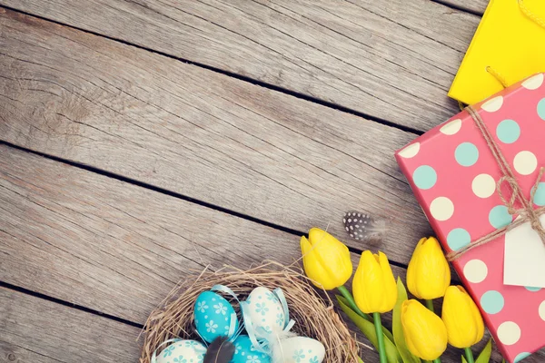 Easter eggs in nest and tulips — Stock Photo, Image