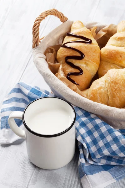 Fresh croissants basket and milk — Stock Photo, Image