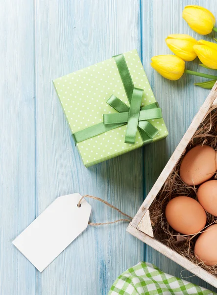 Ovos de Páscoa, tulipas e etiqueta em branco — Fotografia de Stock