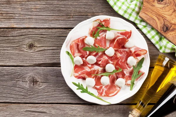 Prosciutto y mozzarella sobre mesa de madera —  Fotos de Stock