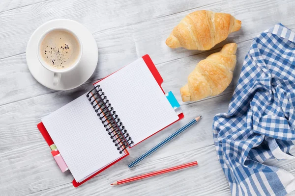 Fresh croissants, coffee and notepad — Stock Photo, Image