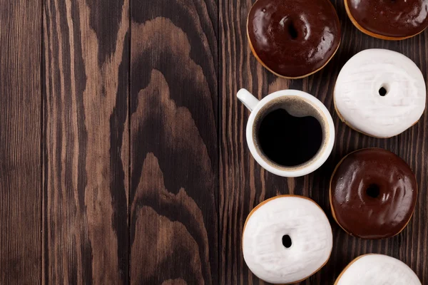 Donuts y café sobre mesa de madera — Foto de Stock