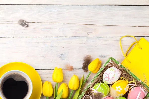 Uova colorate di Pasqua e tulipani gialli — Foto Stock