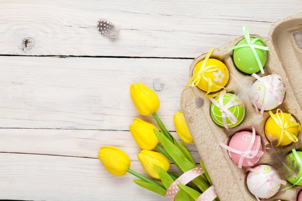 Pasen achtergrond met kleurrijke eieren en tulpen — Stockfoto