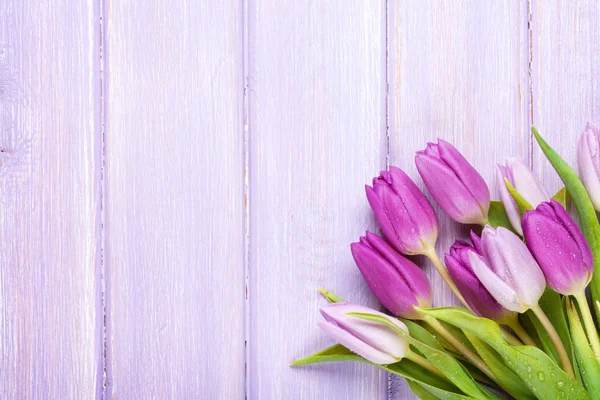 Purple tulips over wooden table — Stock Photo, Image