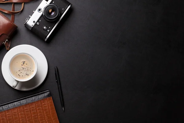 Skrivbord med kamera, kaffe — Stockfoto