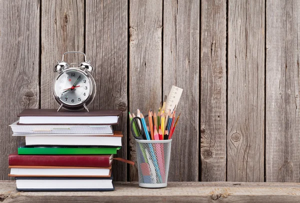 Houten plank met boeken en supplies — Stockfoto