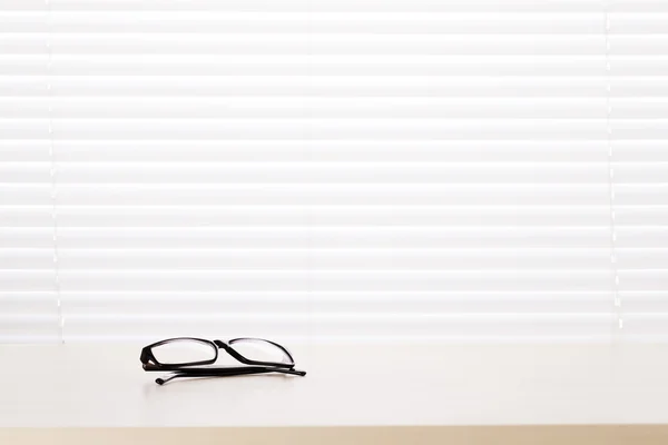 Office desk workplace with glasses on table — Stock Photo, Image